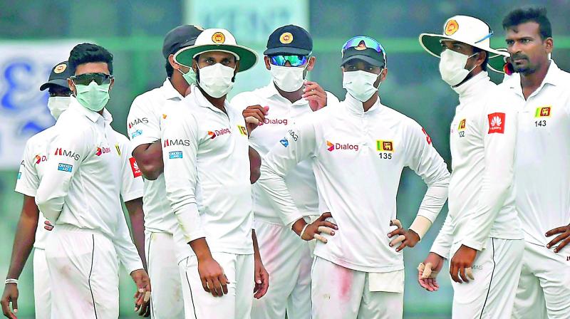 Sri Lankan players wear masks on the field, complaining that air quality had deteriorated during the second day of their third Test against India in New Delhi on  Sunday. Two bowlers walked off, and India declared their innings after Lanka complained they were not in a position to have 11 players on the field. (Photo: PTI)