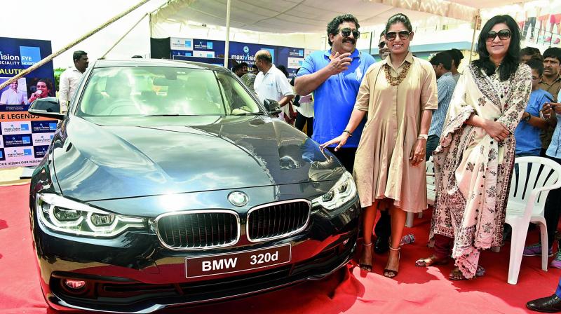 Mithali (right) is all smiles as she poses with her new BMW car alongside Chamundeshwaranath (who gifted her the car) in a presentation event at the Pullela Gopichand Badminton Academy in Hyderabad on Tuesday. (Photo: R. Pavan)