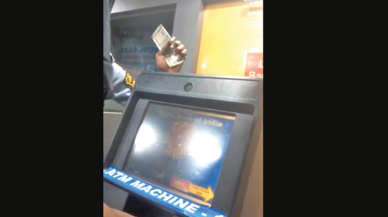 A security personnel with wads of Rs 500 currencies at an ATM in Nandanam on Monday.