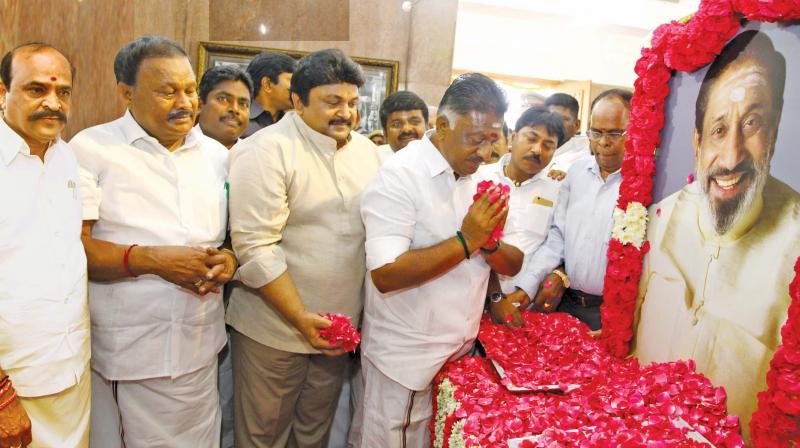 On the occasion of the 90th birth anniversary of late actor Sivaji Ganesan, Deputy Chief Minister O. Panneerselvam pays respects to a portrait of the actor at Manimandapam in Adyar on Monday. Sivajis son actor Prabhu, Dindigul C. Sreenivasan, minister for forests, also present. 	(Photo:DC)