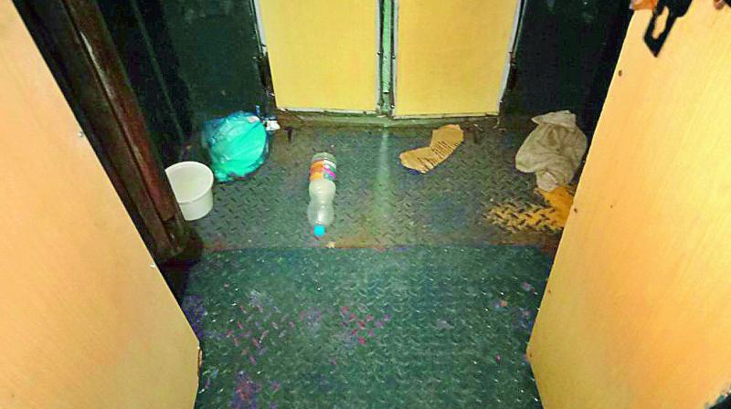 Waste and leftovers spill out of overflowing bins near the washroom in the train. (Photo: DC)
