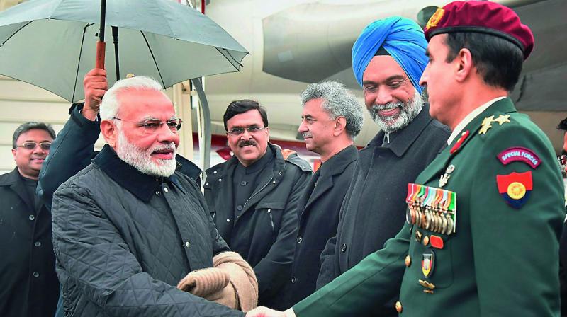 Prime Minister Narendra Modi greets the officials on his arrival at Zurich International Airport to participate in the World Economic Forum, in Davos on Monday. (Photo: PTI)