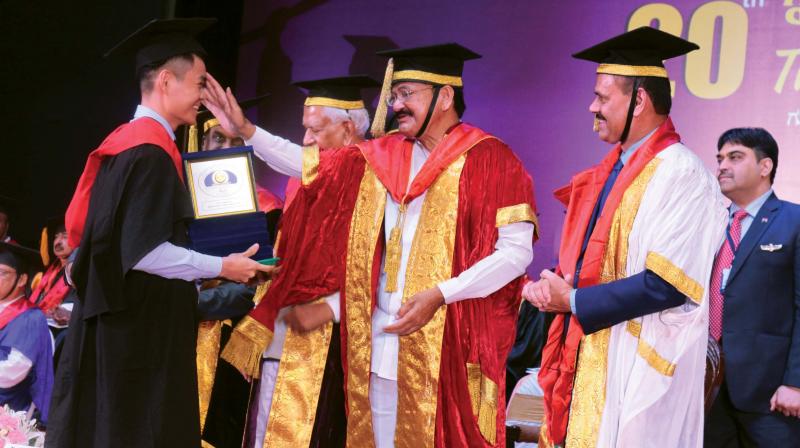 Vice President M. Venkaiah Naidu interacts with student during the 20th convocation of Rajiv Gandhi University of Health Sciences, in Bengaluru on Thursday. 	(Photo:DC)