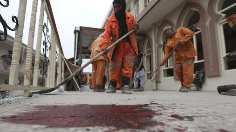 Afghan Municipality workers sweep Baqir-ul Ulom mosque after a suicide attack, in Kabul, Afghanistan. (Photo: AP)