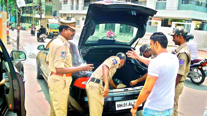 Police personnel inspect a car at Abids in Hyderabad on Tuesday. (Photo: DC)