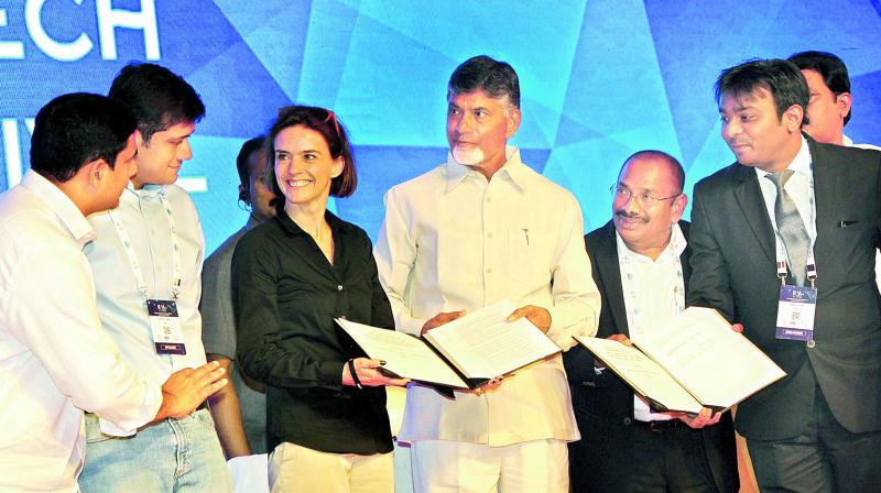 Representatives from various companies exchange files after signing an MoU with the state government in the presence of Chief Minister N. Chandrababu Naidu while IT minister Nara Lokesh looks on at the inaugural session of the Vizag Fintech Festival at a hotel in Visakhapatnam on Tuesday. (Photo: DC)