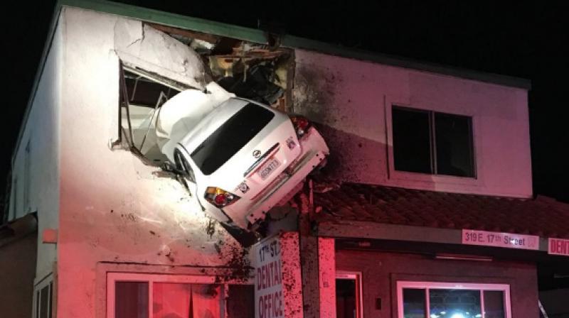 The car appeared stuck through the second story of a dental office. (Photo: Twitter/@OCFA_PIO)