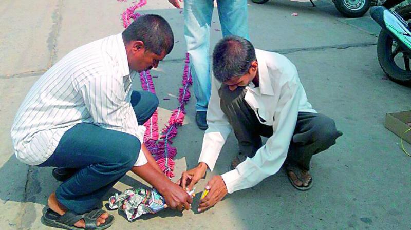 People arrange crackers to celebrate the raid on police official D. Durga Prasads house on Wednesday. (Photo: DC)