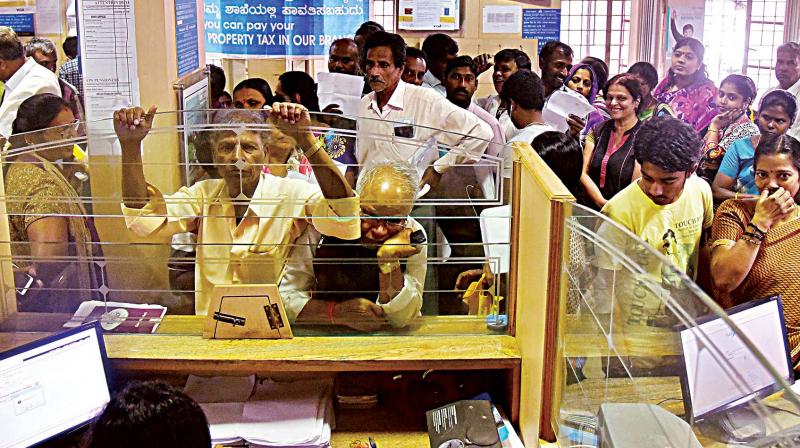 People wait for their turn to exchange demonitised currency notes at a bank in Bengaluru on Thursday. (Photo: DC)