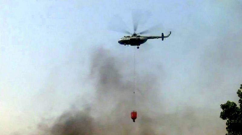 Mi-17 helicopter of the Air Force which made several sorties to pour water to contain what has been classified as the  highest category  blaze in the national capital in the recent times. (Photo: ANI | Twitter)