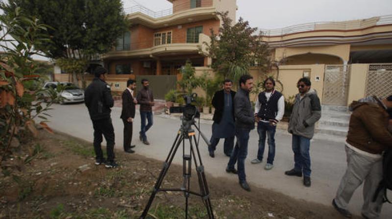 Pakistani journalists and local residents gather out the home of Salman Haider. (Photo: AP)