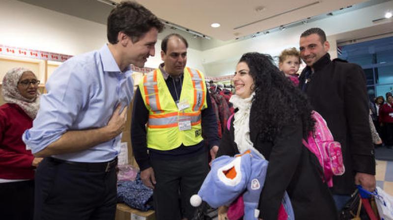 Prime Minister Justin Trudeau, left, greets Georgina Zires, center, Madeleine Jamkossian, second right, and her father Kevork Jamkossian, refugees fleeing from Syria, as they arrive at Pearson International airport, in Toronto. (Photo: AP)