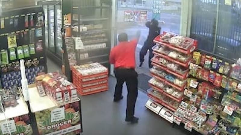 CCTV footage shows how the intruder, who had arrived in a black Hyundai, made a quick exit after the store employee threw small bags of confectionary at him. (Credit: YouTube)