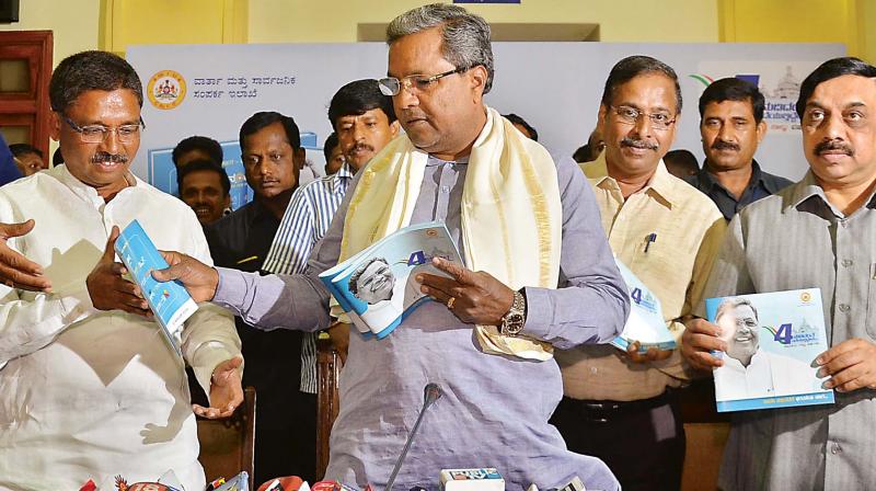 Chief Minister Siddaramaiah releases Nudidanthe Nadiyuthiddeve booklet to mark the fourth anniversary of his government in Bengaluru on Friday. Congress  MLC Ugrappa is seen