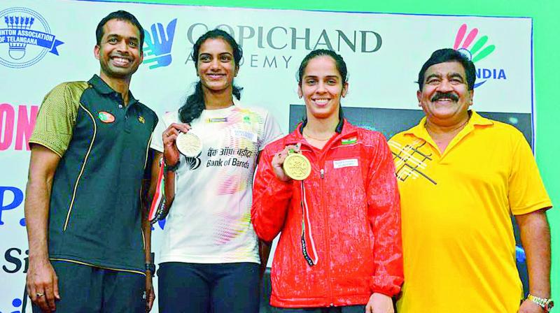 Coach Pullela Gopichand (left) is all smiles as P. V. Sindhu and Saina Nehwal pose with their silver and bronze medals alongside V. Chamundeswarnath during a media interaction at the Pullela Gopichand Academy in Hyderabad on Thursday (Photo: DC)