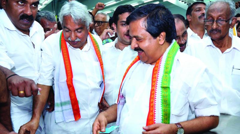 Former chief minister Oommen Chandy punches the ticket at the entry gate at Aluva station before commencing his ride in Kochi Metro in Kochi on Tuesday. Anwar Sadath, MLA, opposition leader Ramesh Chennithala and K.C. Joseph, MLA,  are also seen. (Photo:  DC)