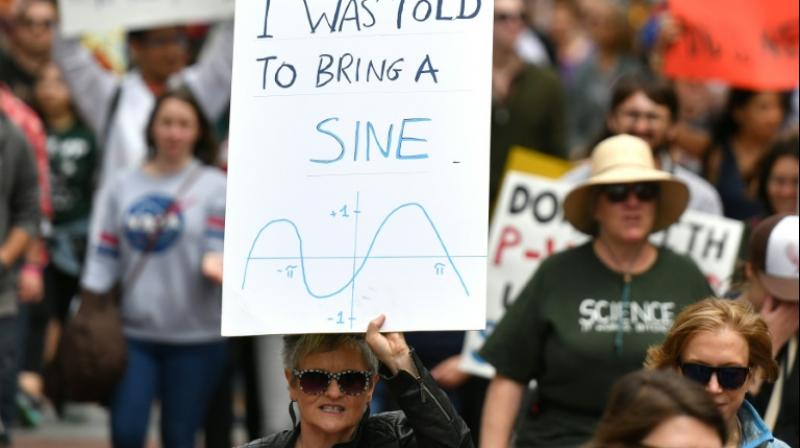 People holds up signs during the March for Science in San Francisco, California on April 22, 2017  (Photo: AFP)