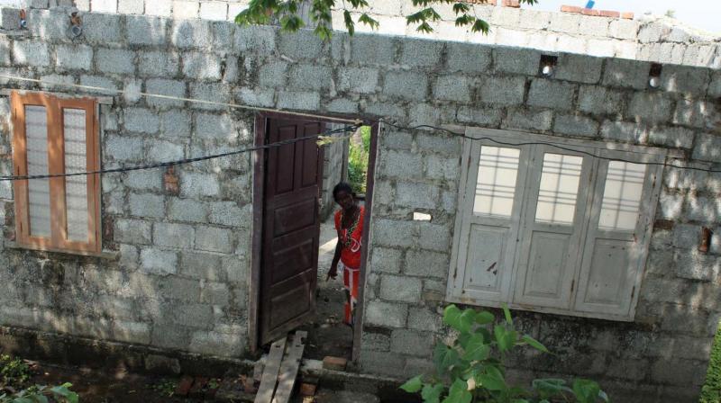 Thankamma, a deaf-and -dumb  woman in Manna Mannathu, shows the damaged parts of her house.