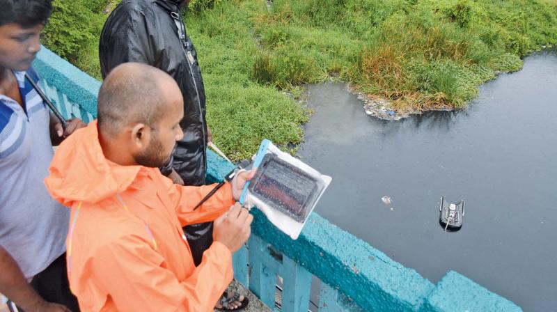 Students of IIT Madras measure water flow in the Cooum river. (Photo: DC)