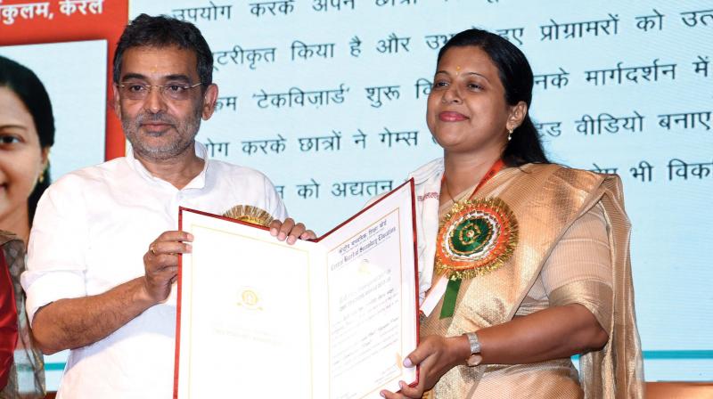 Union Minister of State for HRD Upendra Kushwaha presents the CBSE Teacher Award to Suma Paul in New Delhi.