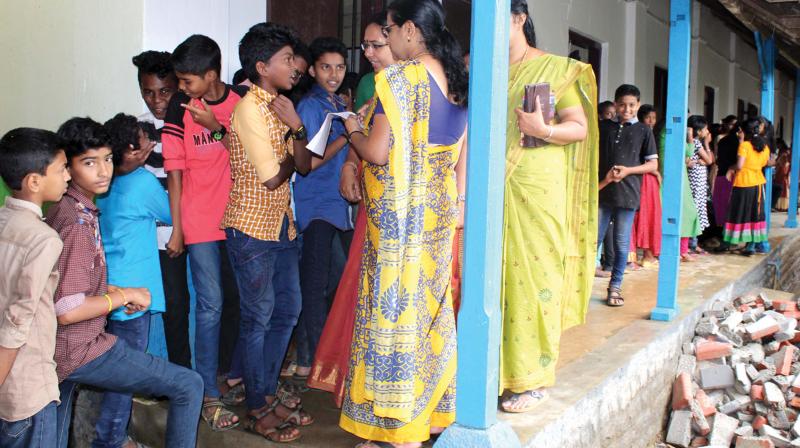 Teachers take list of students who lost uniforms in the floods at Swami Vivekananda Higher Secondary School, Pandanad on Wednesday.