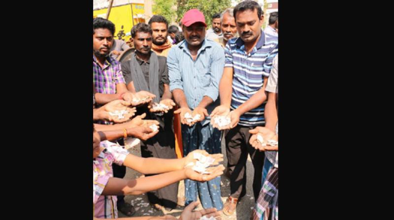 People showing the torn 1,000 notes they collected after a sanitary worker informed them, on Sunday. (Photo: DC)