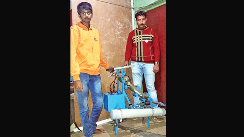 M.Arun, the Govt., higher secondary school-Ooty student and  his mentor L.Sundaram, with  the solar powered water bodies solid waste cleaning robot. (Photo: DC)