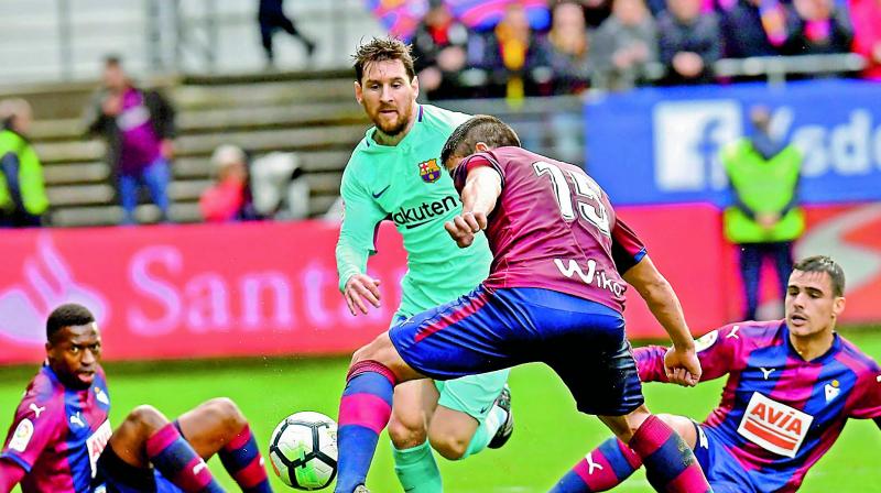 In this file picture, Lionel Messi of Barcelona vies for the ball with players from Eibar during their Spanish league match at the Ipurua stadium in Eibar, northern Spain.