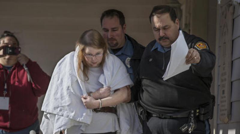 Sara Packer, center, handcuffed, the adoptive mother of Grace Packer, was led out of District Court in Newtown on Sunday. (Photo: AP)