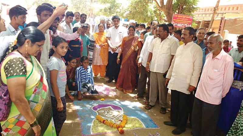 Fed up of bumpy rides, people drew a rangoli portrait of a politician on a pothole in Hubballi  on Sunday. (Photo: DC)