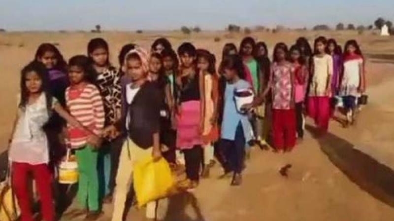 Accompanied by school teacher and other staff workers the girls of Madhya Pradesh village walk 4 km for their basic need. (Photo: ANI | Twitter)