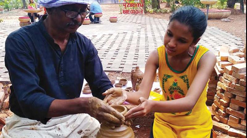 At the beinnale art room, Jacqueline Johnson, a Malayali residing in UAE in her 50s, is trying to shape a pot with the clay.