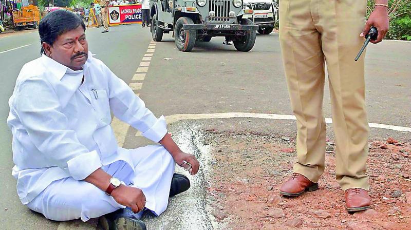 Palasa MLA Syamsundar Sivaji sits on the road at Undavalli Karakatta in protest against police stopping his car to give way to the CMs convoy.