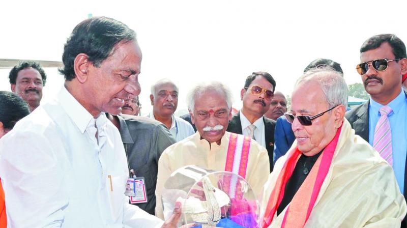 Chief Minister K. Chandrasekhar Rao presents a mememto to President Pranab Mukherjee, who left for Delhi at the end of his Southern Sojourn, as Union minister Bandaru Dattatreya looks on.