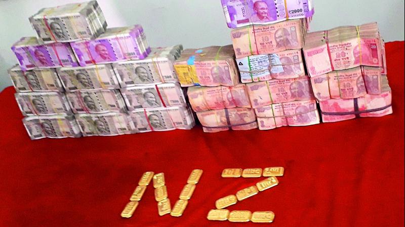Police display the cash and gold seized from various locations in the city on Wednesday.