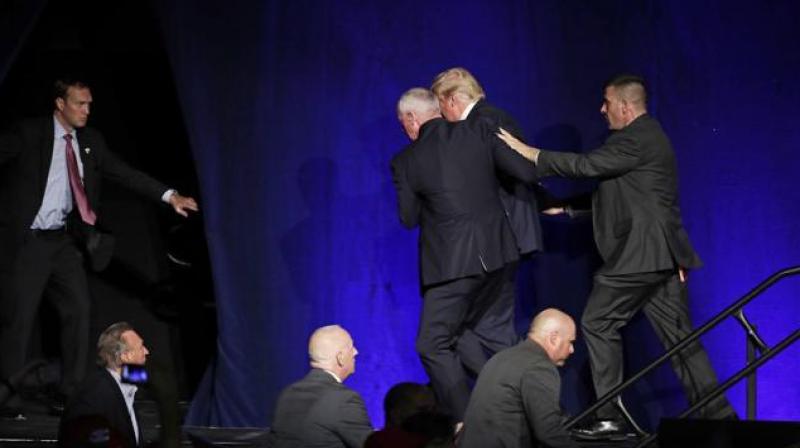 Members of the Secret Service rush Republican presidential candidate Donald Trump off the stage at a campaign rally in Reno, Nevada. (Photo: AP)