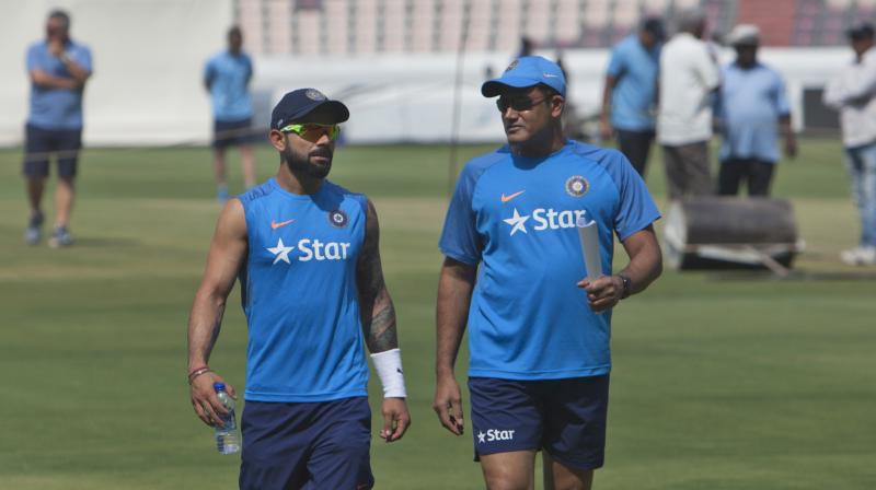 Indian captain Virat Kohli along with coach Anil Kumble walks after inspecting the pitch during a training session on the eve of their test cricket match against Bangladesh in Hyderabad. (Photo: PTI)