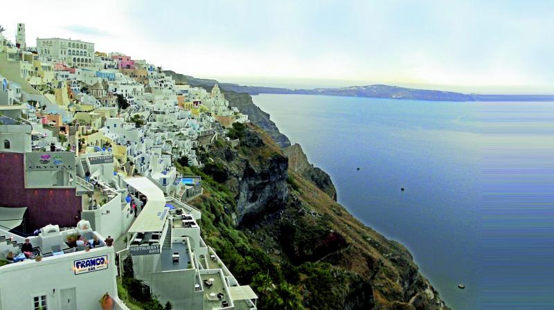White washed houses spilling down the craggy rocks in Santorini.