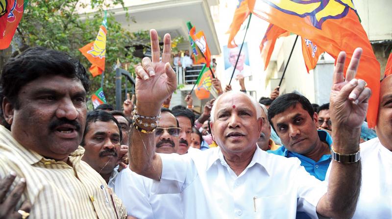 BJP workers celebrate partys victory in the elections to Gujarat and Himachal Pradesh legislative assemblies, in Bengaluru on Monday. (Below) State BJP president B.S. Yeddyurappa flashes victory sign. (Photo: DC)