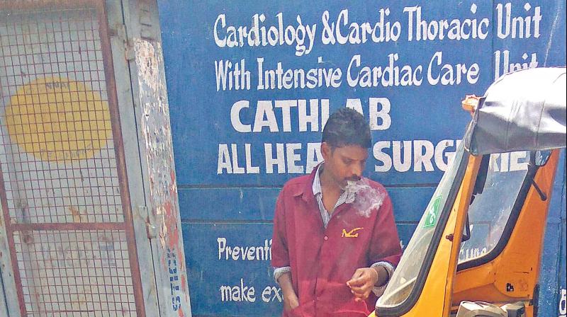 A man smokes inside the  premises of a Primary Health Care centre. (Photo: DC)