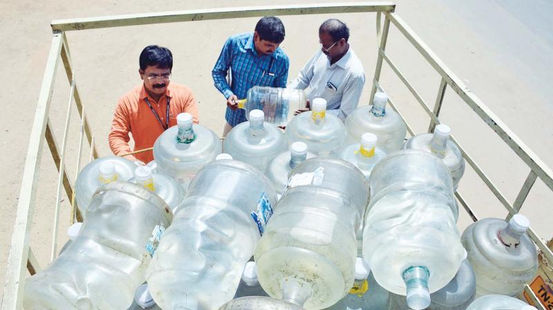 Authorities of FSSAI check labels of water cans  during raids on Saturday. DC