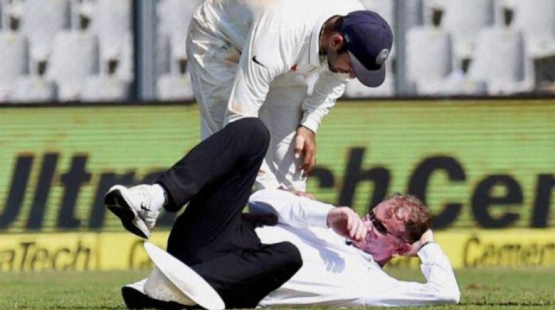 Cheteshwar Pujara helps Umpire Paul Reiffel after he was hit by Bhuvneshwar Kumars throw in Mumbai. (Photo: PTI)