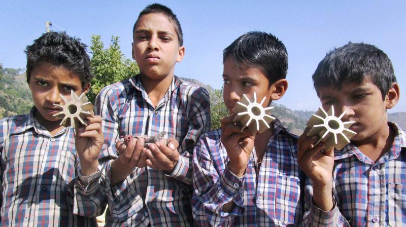 Young boys show parts of a mortar shells fired from across the LOC by Pakistan in village Panjgrain, Rajouri district in Jammu. (Photo: PTI)