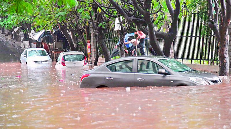 Cars lie half submerged after the rains in the city. (Photo:ANIL KUMAR)