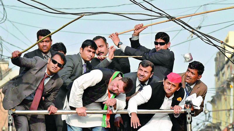 UP Chief Minister Akhilesh Yadav and Congress vice-president Rahul Gandhi duck to avoid hanging cables during a road show in Lucknow on Sunday. (Photo: PTI)