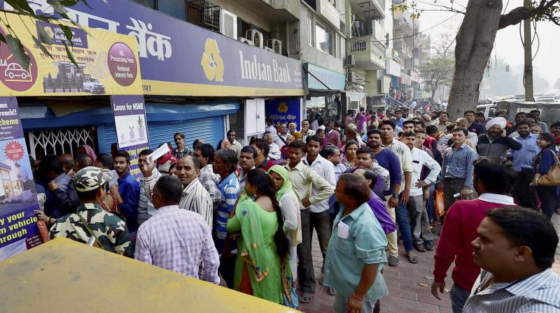 People queue up to get money from an ATM in New Delhi. (Photo: PTI)