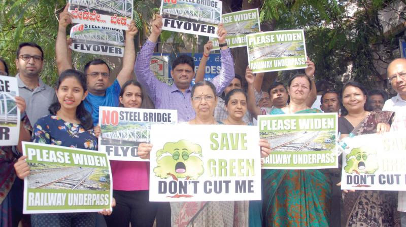 Social activists with Kumara Park residents protest against steel bridge project, at Shivananda Circle in Bengaluru on Sunday. (Photo: DC)