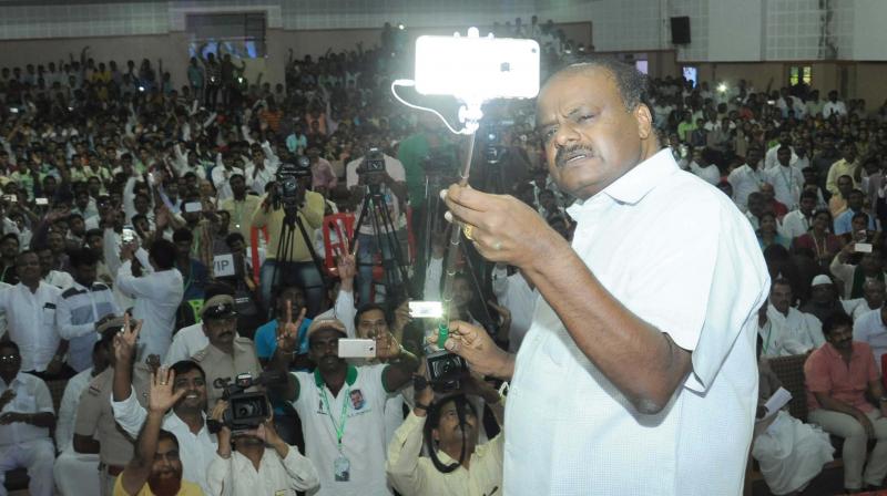 State JD(S) chief H.D. Kumaraswamy takes a selfie during an interaction with PU students in Dharwad on Sunday. (Photo: DC)