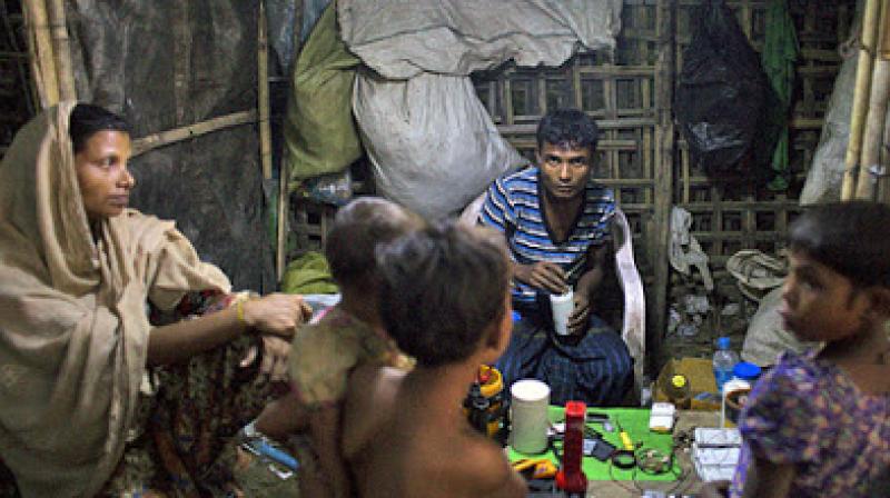 A Rohingya man, woman and children gather in a shop in the Thel-Chaung displacement camp in Sittwe, eastern Myanmars Rakhine state. (Photo: AFP)