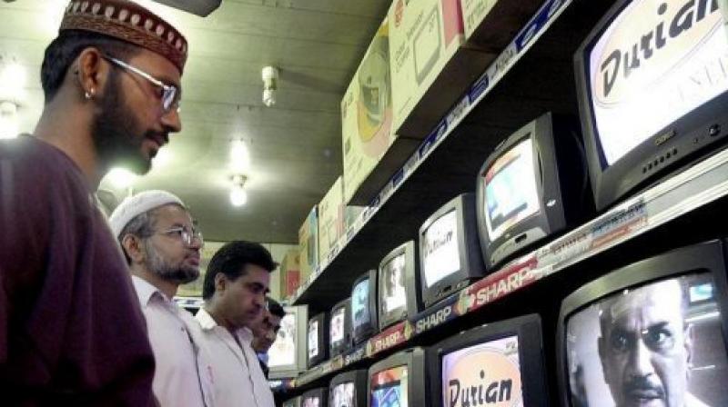People watch TV programes in Karachi. (Photo: AFP)